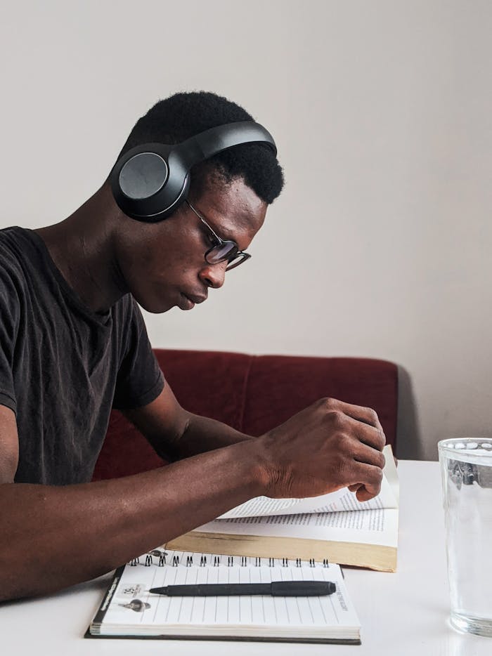 pexels-photo-3466163 Man Wearing Black Crew-neck T-shirt Using Black Headphones Reading Book While Sitting